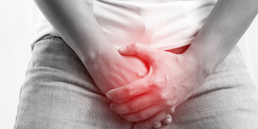 Mann, der sich auf Grund von Pilz am Penis den Schritt hält.